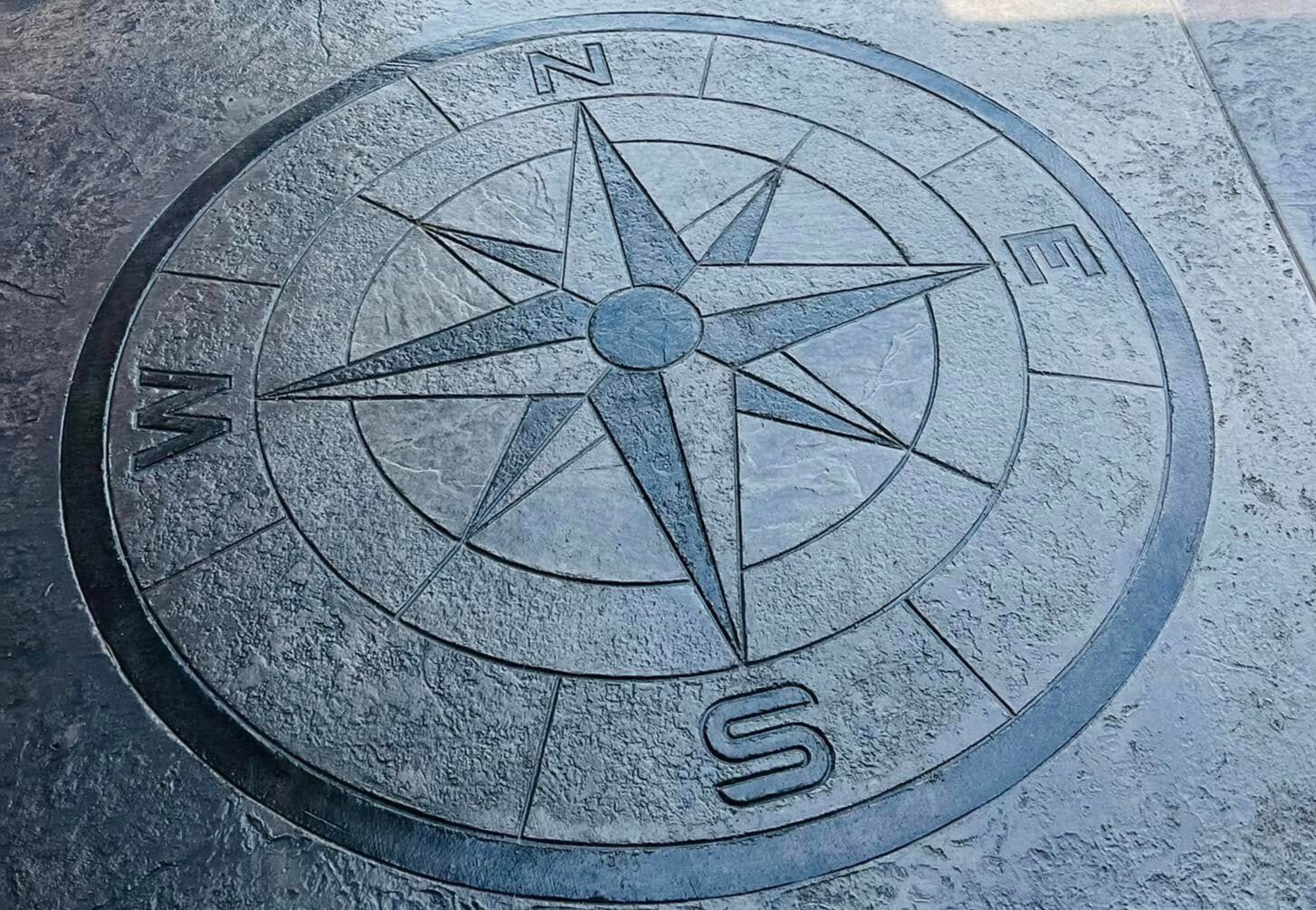 Gray compass-star medallion stamped into a concrete patio