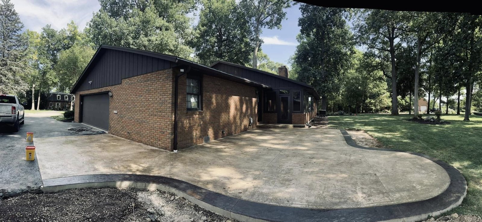 The same brick ranch home with a finished curved concrete patio