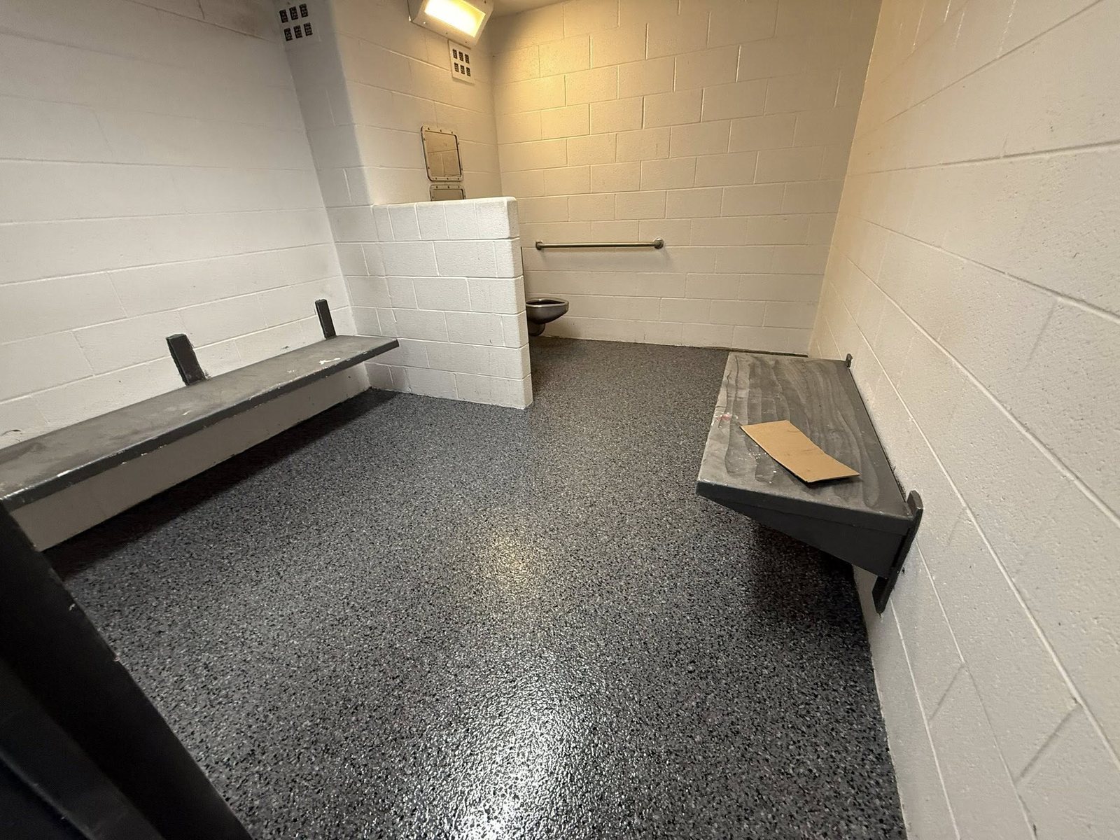 Gray and blue flake epoxy floor with a coved base and bench seating.
