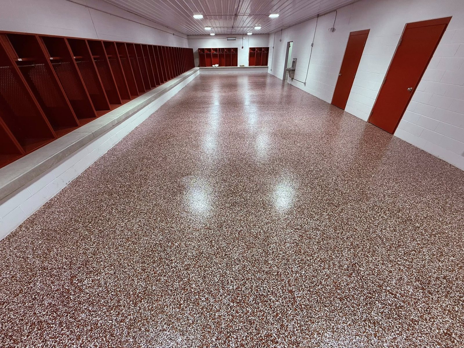 Glossy red flake epoxy locker-room floor with matching red lockers.
