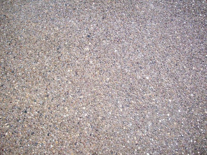 A close-up of a finished exposed-aggregate concrete surface showing the embedded decorative stone.