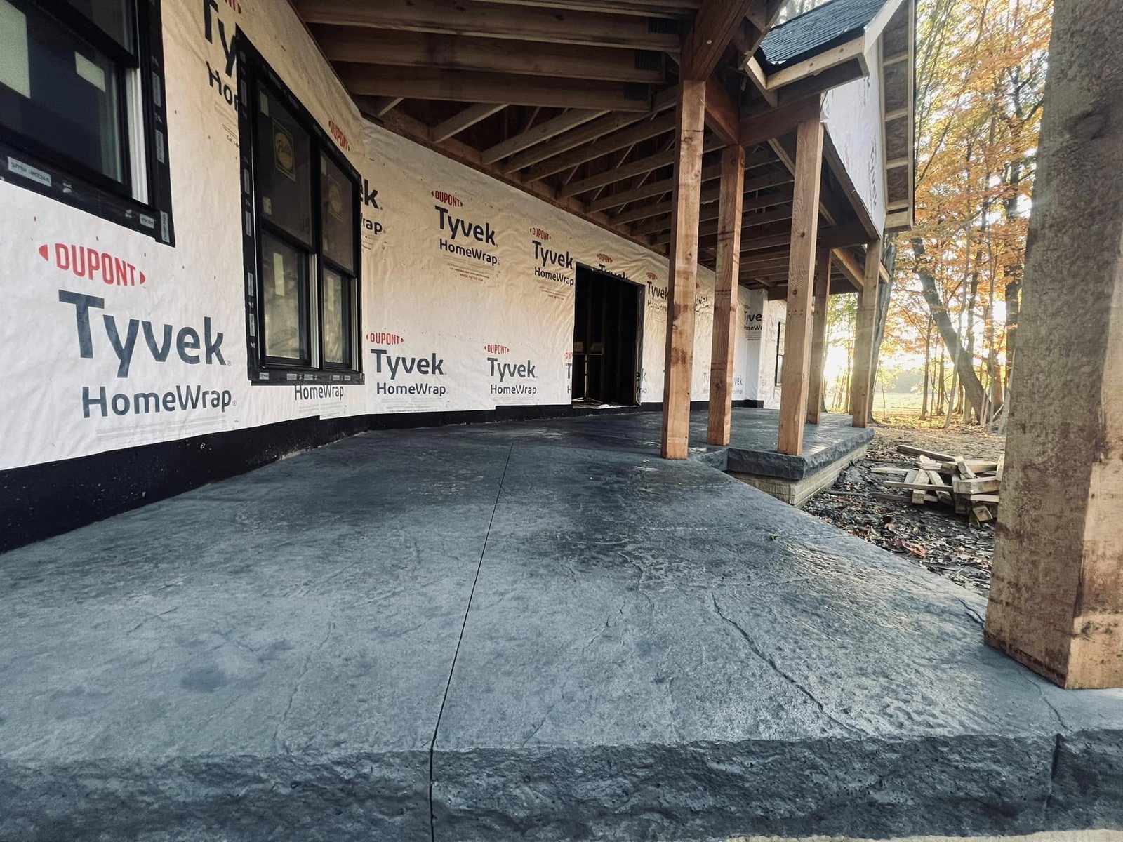 Dark gray slate-pattern stamped concrete patio wrapping a new home exterior.